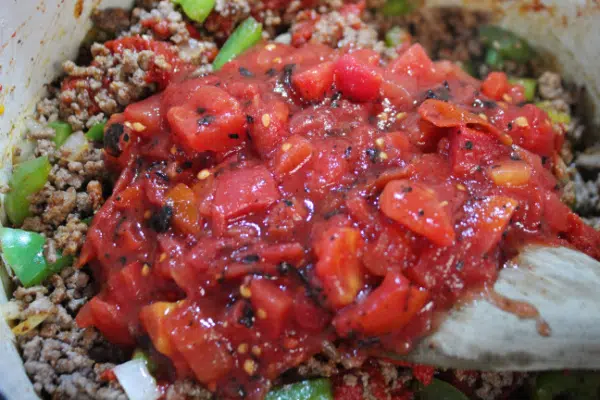 Add diced tomatoes  to the ground beef.